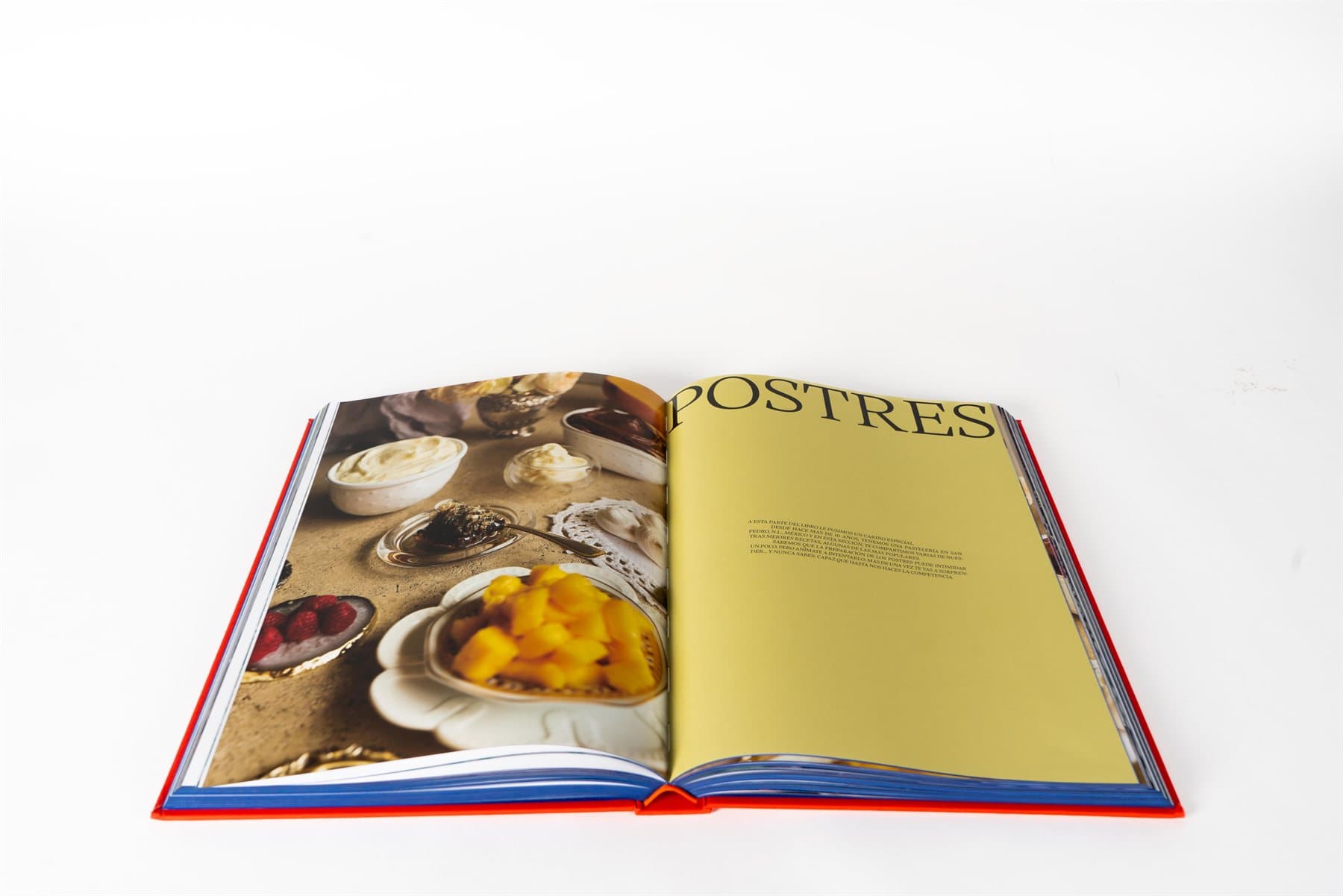 Spread del libro Dish List abierto: capítulo de Postres. Página izquierda con fotografía editorial de fruta, mole y pequeños platos; página derecha con el título POSTRES sobre fondo amarillo y texto introductorio.