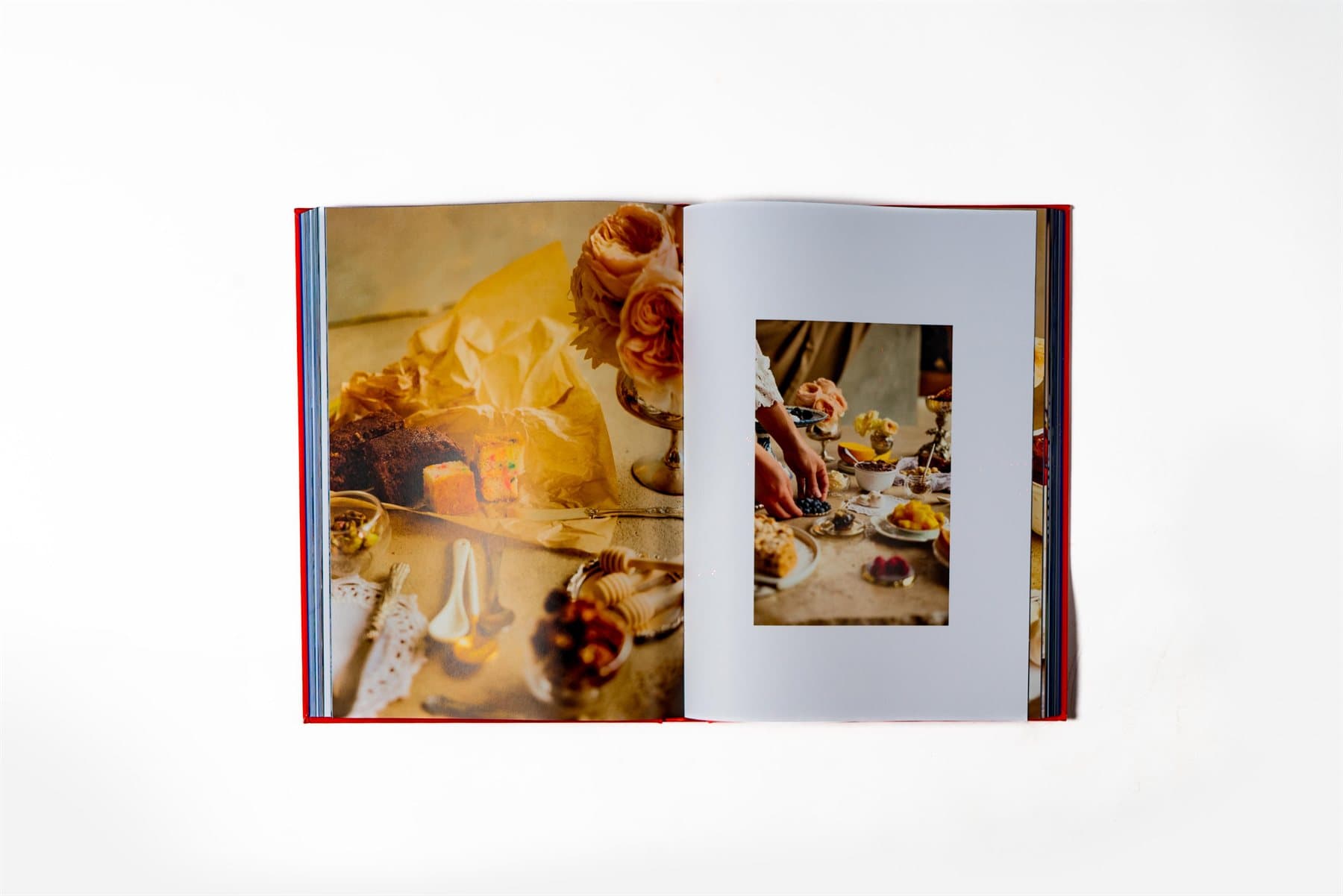 Spread del libro Dish List abierto: página izquierda con composición editorial de pastel, cubos de fruta y rosas color durazno sobre superficie de mármol; página derecha con foto inset de manos preparando un postre con frutos rojos.